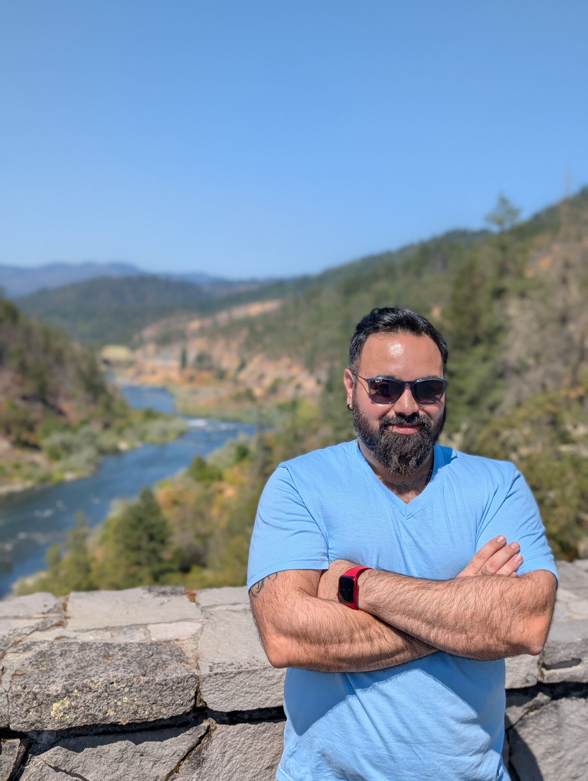 The Cash Navigator founder standing outdoors with a mountain range and river in California